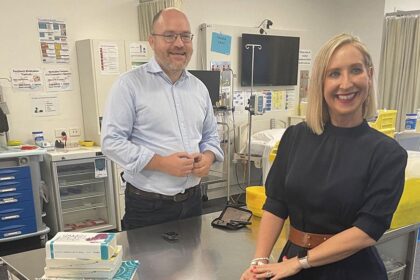 Dr Steven James checking his blood glucose levels after his presentation with the 2024 Charles Campbell Coghlan OAM Emerging Researcher Award by Diabetes Australia Group CEO Justine Cain