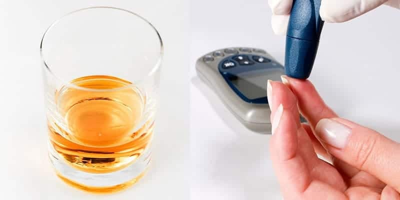 Glass of alcohol on a table and person checking their blood sugar