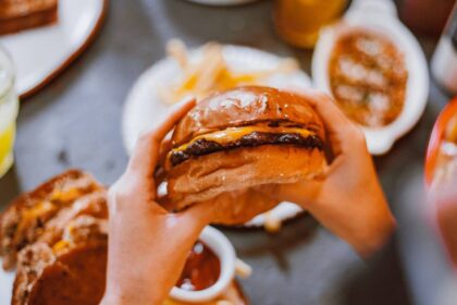 Hands holding a cheeseburger