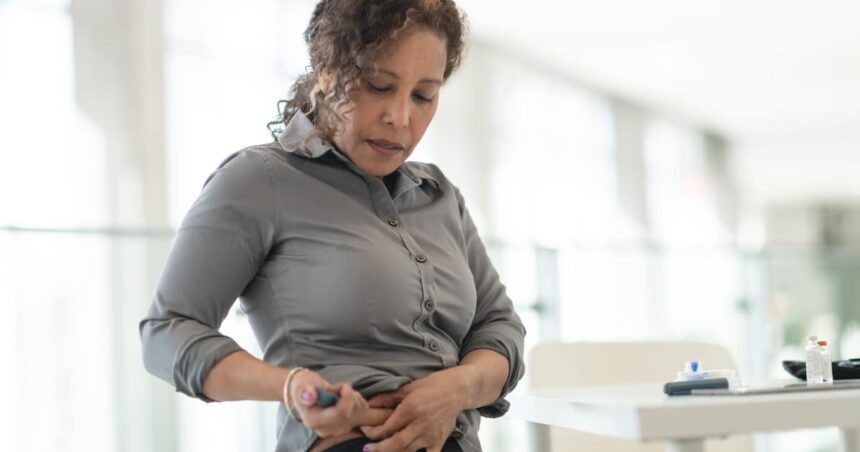 Image of a women injecting a medication pen into her abdomen