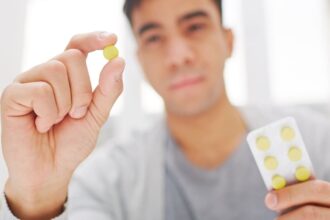 Man holding combination drug pill