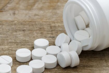 Metformin pills spilling out of a bottle onto a table