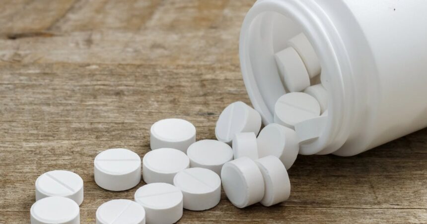 Metformin pills spilling out of a bottle onto a table