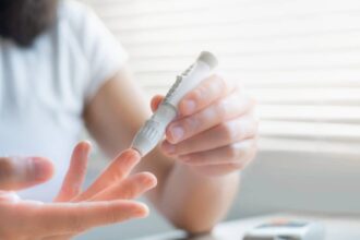 Woman measuring her blood sugar to test for reactive hypoglycemia