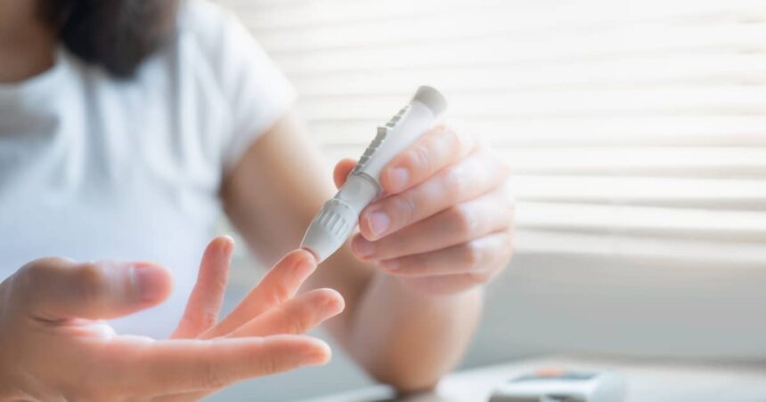 Woman measuring her blood sugar to test for reactive hypoglycemia