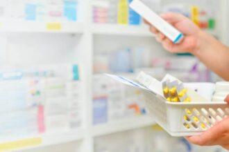 Image of a pharmacist reading the label of a medication box