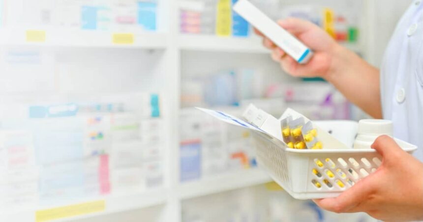 Image of a pharmacist reading the label of a medication box