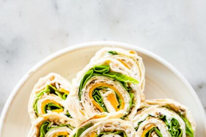 Multiple turkey pinwheel sandwiches on a plate.