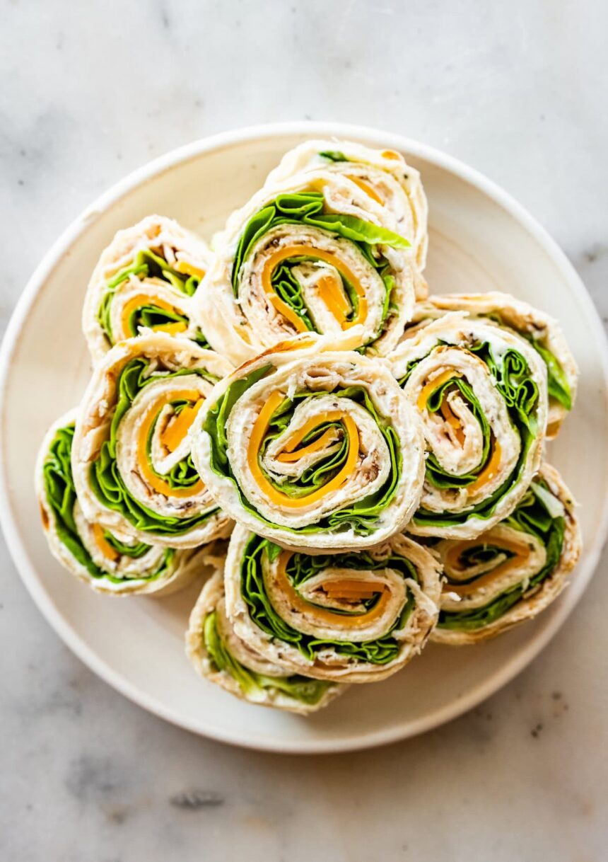 Multiple turkey pinwheel sandwiches on a plate.