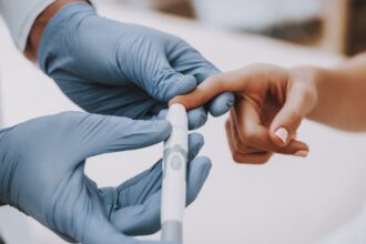 Image of doctor pricking a patient