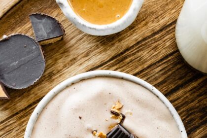 A bowl full of peanut butter cup protein fluff topped with chunks of peanut butter cups.