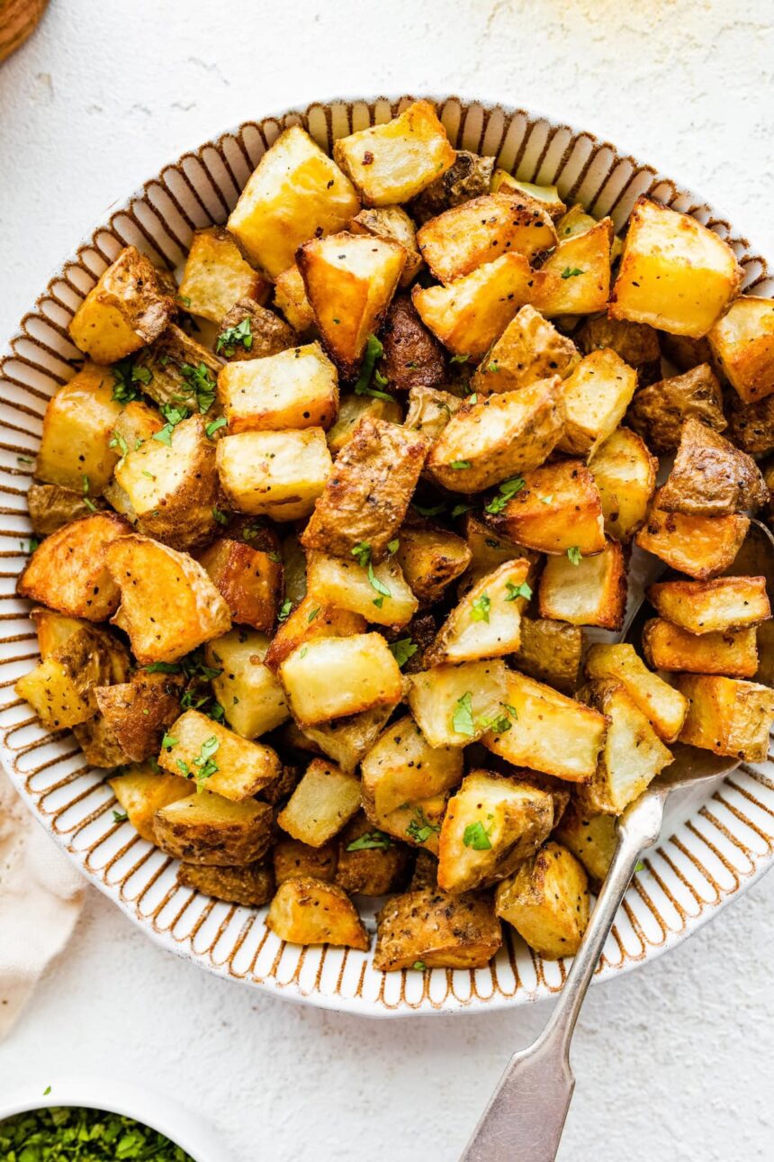 Roasted potatoes garnished with fresh parsley in a bowl.