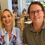 Justine Cain and James Ashman sit behind a white table