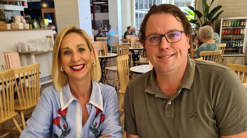 Justine Cain and James Ashman sit behind a white table